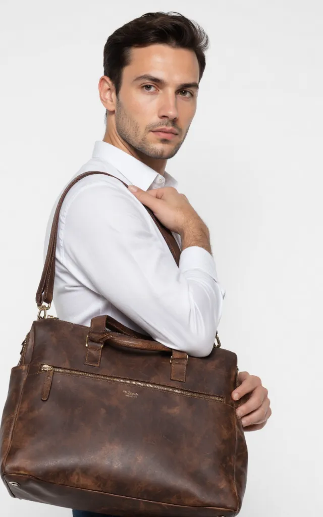 A French male model with a Men's bag, wearing a shirt, against a white background, in a front   facing close   up